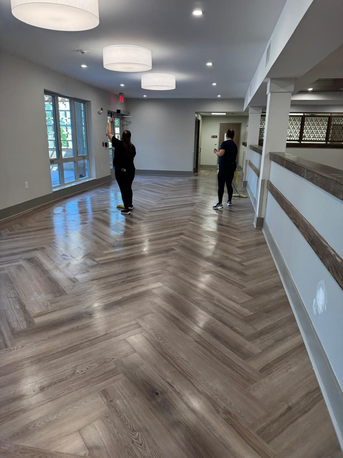 Solutions Cleaning team cleaning the herringbone floor of a newly built lobby