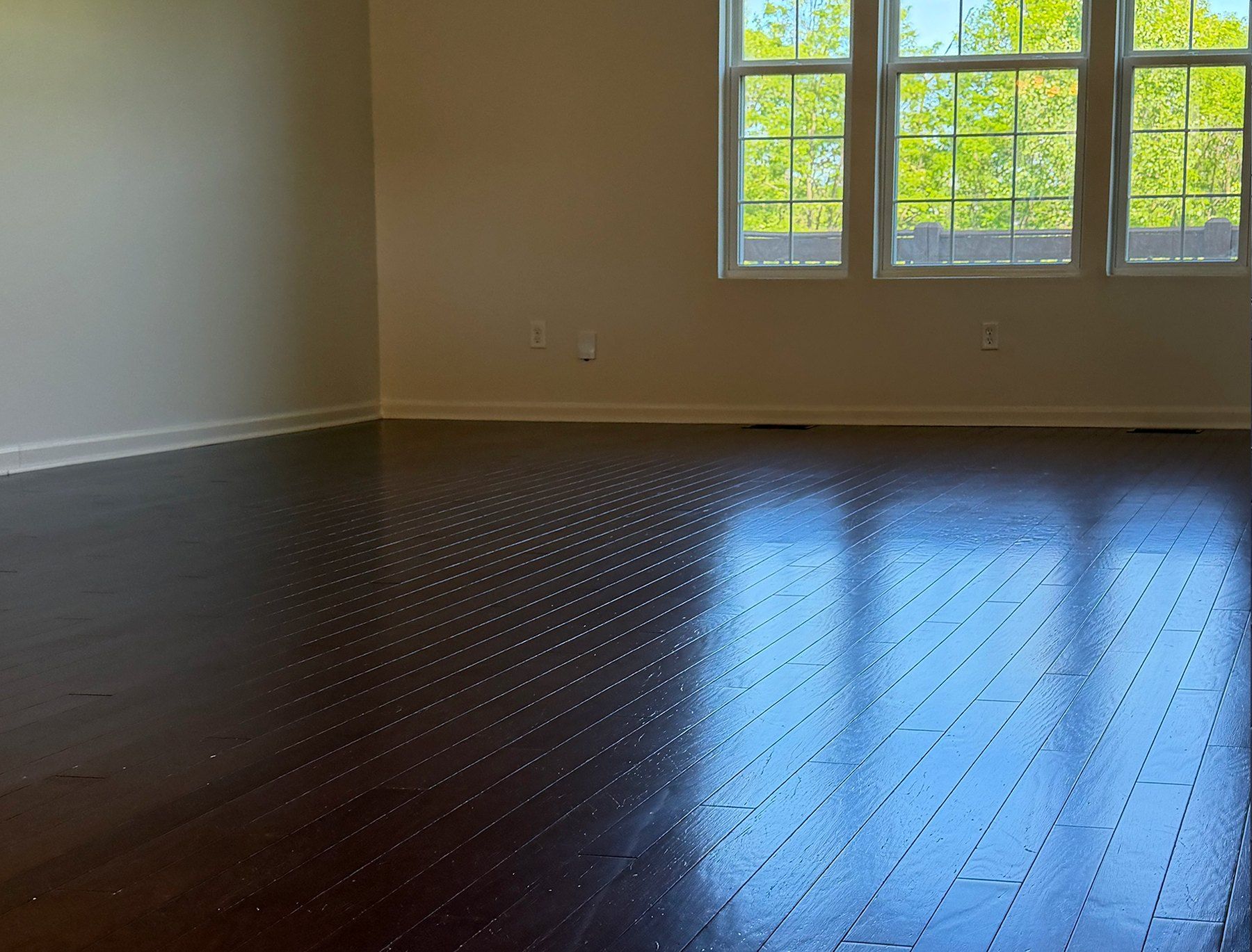 Empty room with freshly cleaned, gleaming hardwood floors after a move-out cleaning