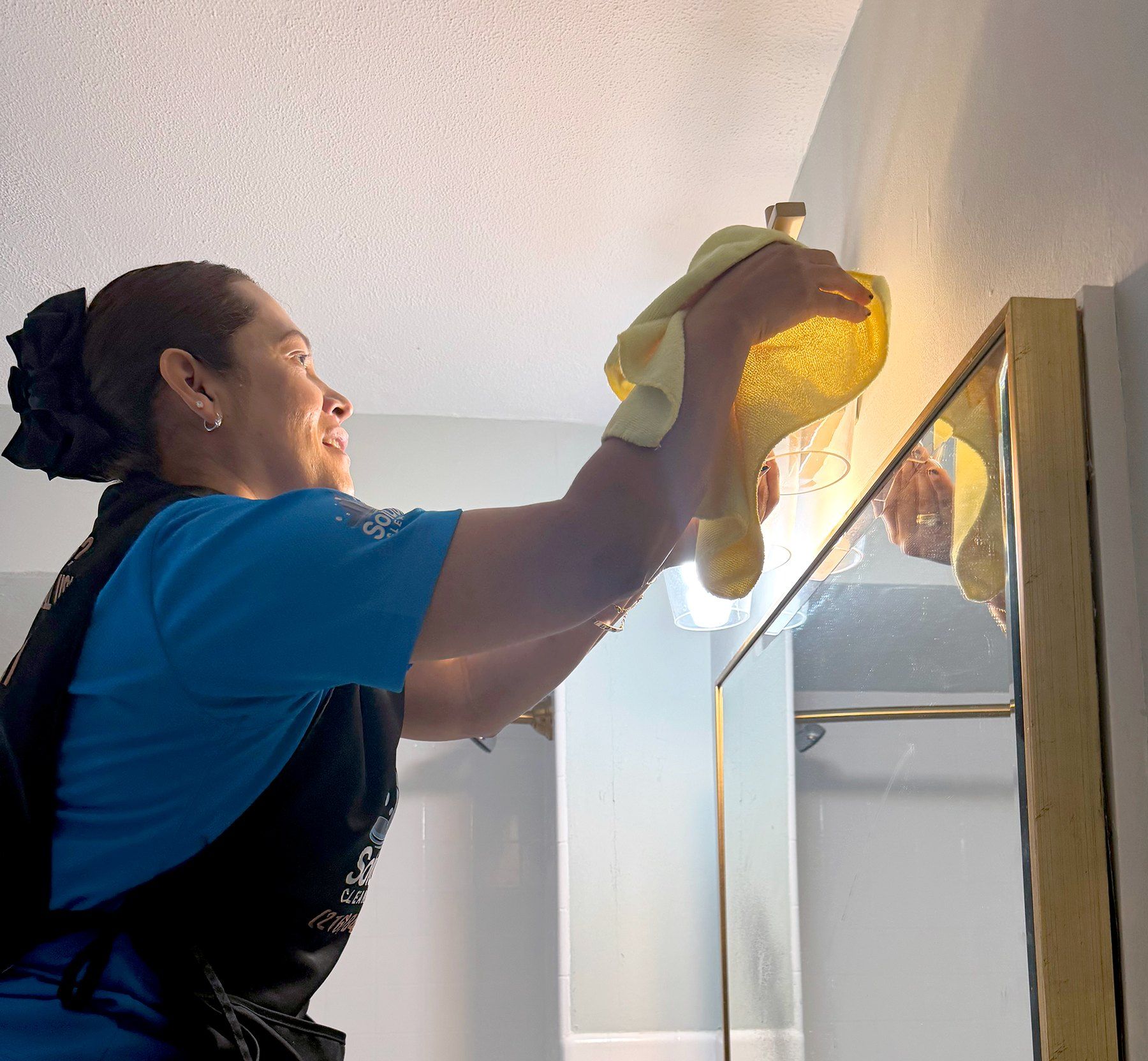 Solutions Cleaning team member dusting a staircase railing in a Cleveland-area home